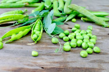 Bakla genç yeşil bezelye ve bezelye eski rustik ahşap arka plan üzerinde. Karanlık rustik tarzı.