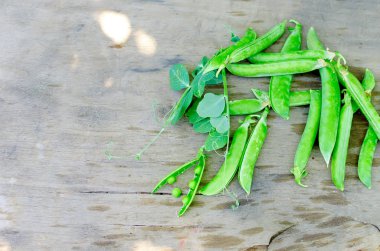 Bakla genç yeşil bezelye ve bezelye eski rustik ahşap arka plan üzerinde. Karanlık rustik tarzı.