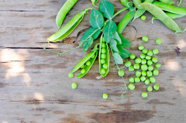 Bakla genç yeşil bezelye ve bezelye eski rustik ahşap arka plan üzerinde. Karanlık rustik tarzı.