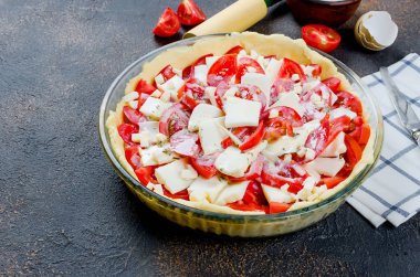 bir pişirme çanağı ve malzemeler için peynir ve domates koyu arka plan üzerinde kopya alanı, üstten görünüm ile Yunan pasta pişirme için hamur ham Bankası