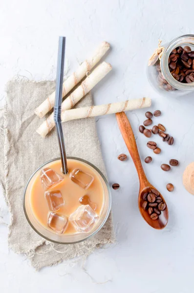 coffee ice in glass and coffee beans  on a gray  table, top view, copy space