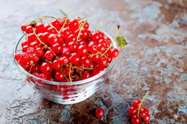 Olgun taze kırmızı kuş üzümü meyveleri koyu rustik arka plan üstten görünüm, kopya alanı üzerinde cam kapta