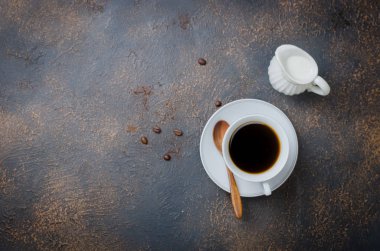 uçan daire, sütçü ve kahve tozu bir banka karanlık beton eski arka plan üzerinde beyaz bir fincan siyah koyu kahve