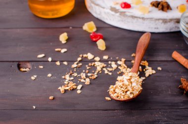 Tahta kaşık ve malzemelerin eski rustik beyaz arka plan üzerine ev yapımı Granola sağlıklı kahvaltı