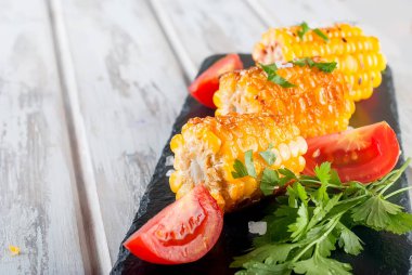 Lezzetli Barbecued Mısır koçanı otlar, sebzeler ve tuz bir beyaz eski ahşap tablo 