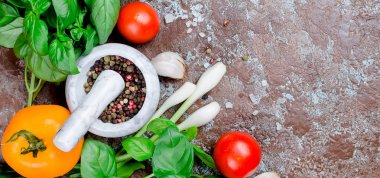 Olgun kırmızı ve sarı domates, yeşil soğan ve fesleğen, sarımsak, tuz ve baharat karanlık bir taş zemin üzerine. Üstten görünüm, kopya alanı. 