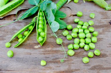 Bakla genç yeşil bezelye ve bezelye eski rustik ahşap arka plan üzerinde. Karanlık rustik tarzı.