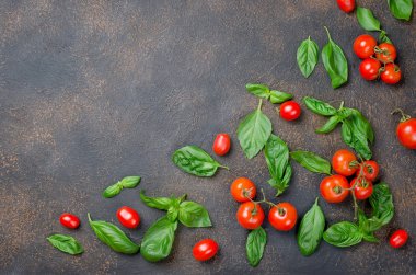 bir sürü dağınık Yeşil taze fesleğen yaprakları ve kiraz domates bir karanlık paslı eski arka plan üzerinde en iyi görünümü kapatın, alanı Kopyala