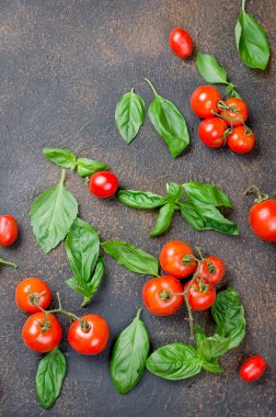 bir sürü dağınık Yeşil taze fesleğen yaprakları ve kiraz domates bir karanlık paslı eski arka plan üzerinde en iyi görünümü kapatın, alanı Kopyala