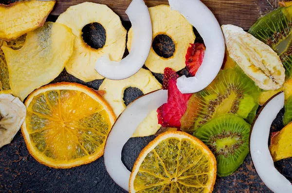 Fruit chips on dark background, concept of healthy and proper nutrition, snack, top view, copy spac