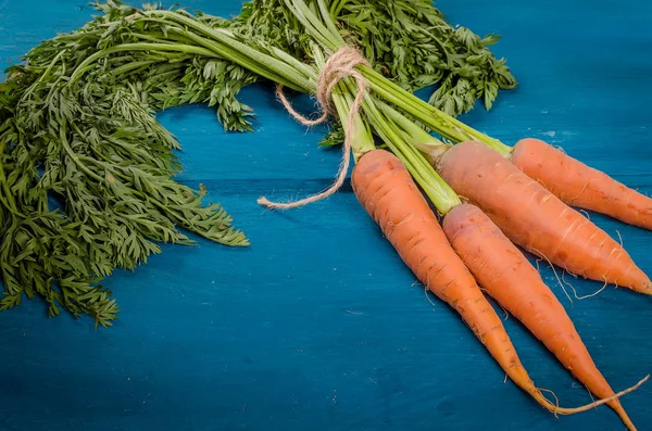 Gjeng Ferske Gulrøtter Med Grønne Blader Gammel Blå Trebakgrunn Grønnsaker – stockfoto