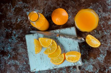 portakal suyu bir bardak ve bir şişe ve parça üstünde a beton kahverengi-mavi arka plan kopya yer Orange