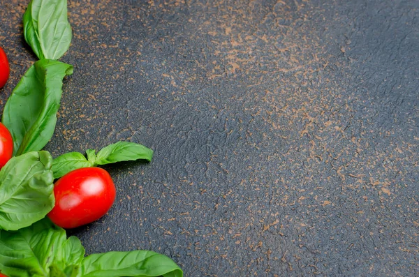 bir sürü dağınık Yeşil taze fesleğen yaprakları ve kiraz domates bir karanlık paslı eski arka plan üzerinde en iyi görünümü kapatın, alanı Kopyala