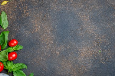 bir sürü dağınık Yeşil taze fesleğen yaprakları ve kiraz domates bir karanlık paslı eski arka plan üzerinde en iyi görünümü kapatın, alanı Kopyala