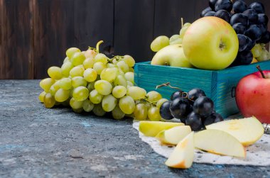 Taze sarı elma, beyaz ve mavi üzüm, tablo, dilim meyve ve meyve deri üzerinde rulo koyu arka plan üzerinde. Detoks kavramı. Sağlıklı gıda, meyve inanılmaz şeker. seçici odak, kopya alanı 