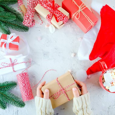 Çocuk Noel tutan hediye kutusu bağlı ile hatmi beyaz zemin üzerine kırmızı kurdele, kırmızı Kupası kakaolu. Noel kartı tatil kavramı, kopya alanı