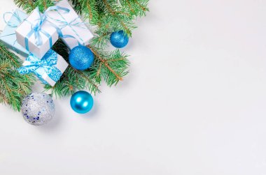 Noel dekoratif arka plan çam dalları, koniler, gümüş ve mavi Noel top ve tojs, hediyeler ve ribbinon beyaz arka plan ile. kart tatil kavramı. kopya alanı, üstten görünüm.