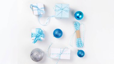 Noel dekoratif arka plan çam dalları, koniler, gümüş ve mavi Noel top ve tojs, hediyeler ve ribbinon beyaz arka plan ile. kart tatil kavramı. kopya alanı, üstten görünüm.