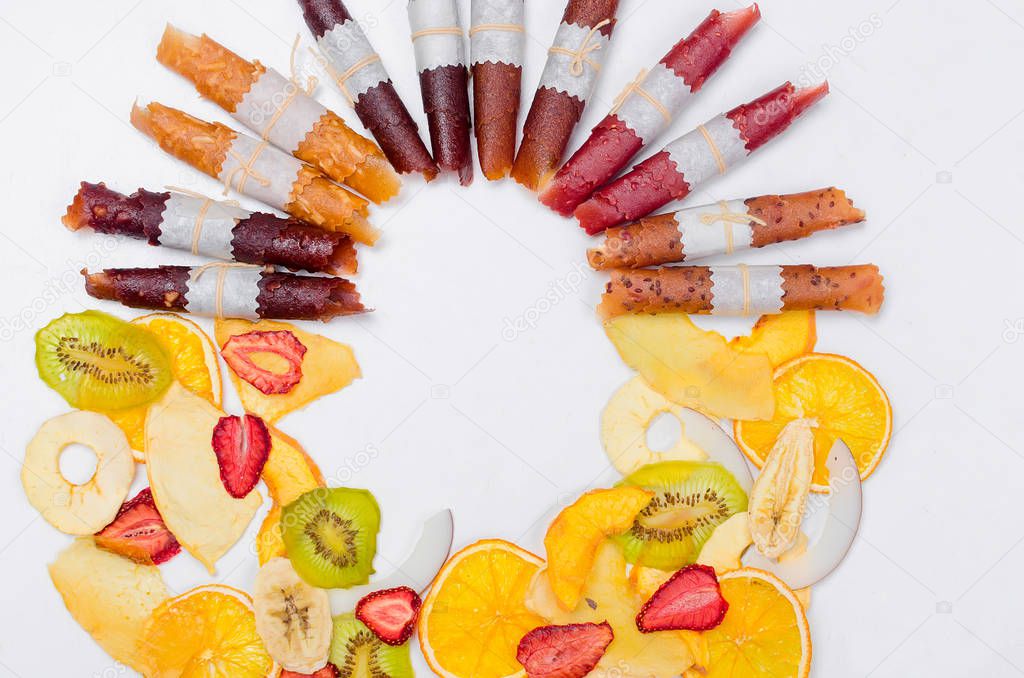 varietty of dry fruit chips and fruit leather rolls on white background with an empty space for text,. Detox concept. Healthy food, Fruits amazing candy.