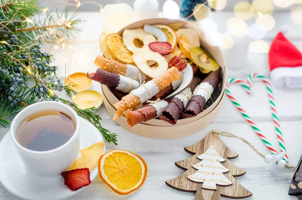warming Tea and round wooden gift box with Many variety of dry  fruit chips and fruit leather rolls on white background in the winter Christmas day, Holidays concept. Detox concept. Healthy food, Fruits amazing candy. selective focus,