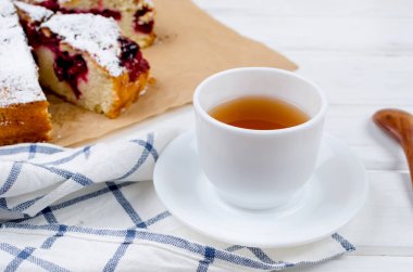 Kiraz veya erik pasta serpilir ile krema şeker, beyaz çay ahşap panoları, yakın çekim, görüntülemek yukarıdan 