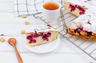 Kiraz veya erik pasta serpilir ile krema şeker, beyaz çay ahşap panoları, yakın çekim, görüntülemek yukarıdan 
