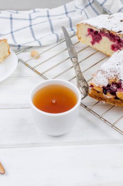 Kiraz veya erik pasta serpilir ile krema şeker, beyaz çay ahşap panoları, yakın çekim, görüntülemek yukarıdan 