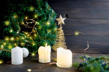 Mumlar ve dekoratif altın Noel ağacı, zanaat hediyeler, çam dalları ve koyu arka plan ışıkları Noel kompozisyonu. kart tatil kavramı. kopya alanı, 