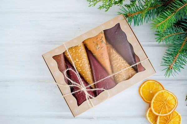fruit pastila fruit leather cones in a gift box on Christmas on white table copy space, Holidays concept. healthy eat