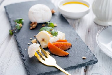 Bir fincan sütlü kahve, beyaz kalıp, ceviz, armut ve beyaz ahşap masa, doğal ışık, sağlık gıda kavramı günü kahvaltıda bal ile yumuşak peynir