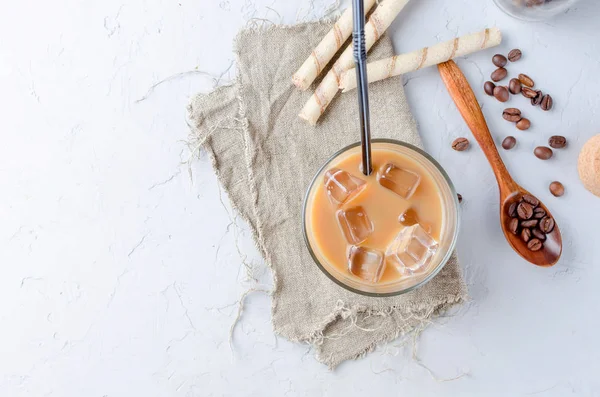 coffee ice in glass and coffee beans  on a gray  table, top view, copy space