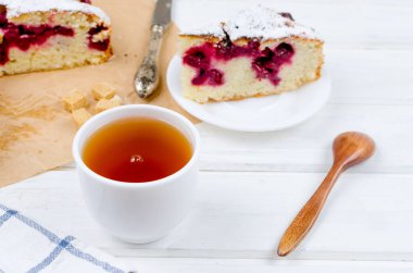 Kiraz veya erik pasta serpilir ile krema şeker, beyaz çay ahşap panoları, yakın çekim, görüntülemek yukarıdan 