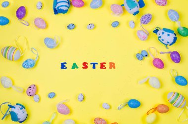 ortaya konulan çeşitli dekoratif yumurta Paskalya yazıt Merkezi, üstten görünüm, düz lay, tatil arka plan, kopya alanı ile sarı bir arka plan üzerinde
