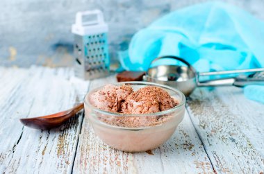 Beyaz bir kırsal masada kasedeki çikolatalı dondurma topu. Boşluğu kopyala.