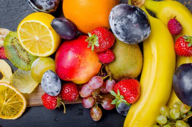 birçok farklı koyu arka plan, sağlıklı ve uygun beslenme, Aperatif, üstten görünüm, kavramı üzerinde mevsimlik olgunlaşmış sulu meyve karışık kopyalama alanı