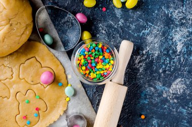 Mutlu Paskalya kartı. Kurabiye ustası, kesimler, şeker yumurta ve pişirme için malzemeler hamur hamur rulo