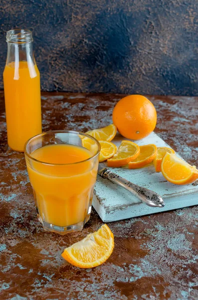 Narancslé Egy Pohár Egy Üveg Narancs Egy Konkrét Barna Kék — Stock Fotó