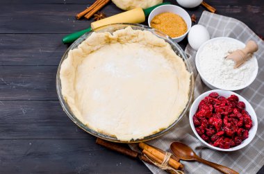 Pasta bir cam temel yuvarlak formu ve malzemeyi kek - un, yumurta, kiraz, kahverengi şeker, cinamon karanlık eski ahşap masa üzerinde yapmak için. Vişneli pasta serisi yapma, 