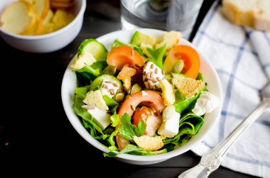 Taze ışık yeşil salata salatalık, marul, avokado, domates, koyu ahşap masa üzerinde lanch istiyo sseeds ve cam su ile. Gıda sağlıklı yaşam konsepti. Düz yatıyordu. Metin, doğal ışık, seçici odak için yer kopyalayın