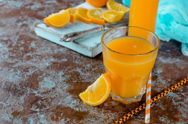 portakal suyu bir bardak ve bir şişe ve parça üstünde a beton kahverengi-mavi arka plan kopya yer Orange