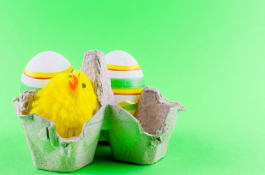 iki dekoratif eggsin ve bir oyuncak tavuk içinde bir tepsi ortaya konulan bir yeşil arka plan, tatil arka plan, kopya alanı