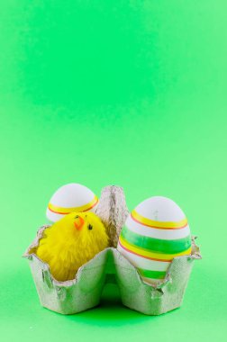 iki dekoratif eggsin ve bir oyuncak tavuk içinde bir tepsi ortaya konulan bir yeşil arka plan, tatil arka plan, kopya alanı