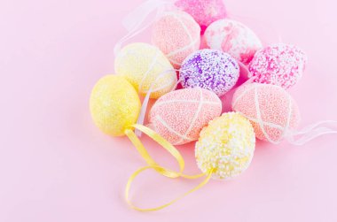 renkli dekoratif yumurtalar hafif pembe bir arka plan üzerinde dağınık. tebrik kartı Paskalya, üstten görünüm, düz lay, tatil arka plan, kopyalama alanı