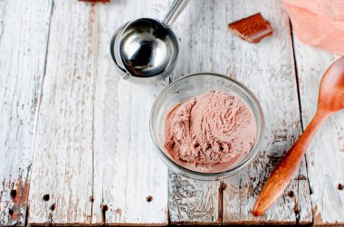 Beyaz bir kırsal masada kasedeki çikolatalı dondurma topu. Boşluğu kopyala.