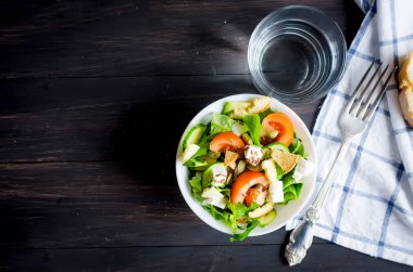 Taze ışık yeşil salata salatalık, marul, avokado, domates, koyu ahşap masa üzerinde lanch istiyo sseeds ve cam su ile. Gıda sağlıklı yaşam konsepti. Düz yatıyordu. Metin doğal ışık, seçici odak için alanı Kopyala