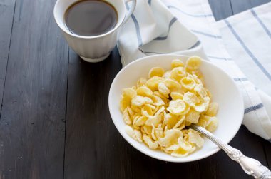 Kuru Mısır gevreği beyaz tabak, şişe süt ile ve eski rustik ahşap masa günü kahvaltıda güçlü kahve alanı, doğal ışık kopyalama