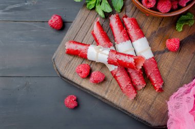 Olgun taze sulu Ahududu ve koyu arka plan üzerinde meyve deri rulo. Detoks kavramı. Sağlıklı gıda, meyve inanılmaz şeker. kopya alanı,