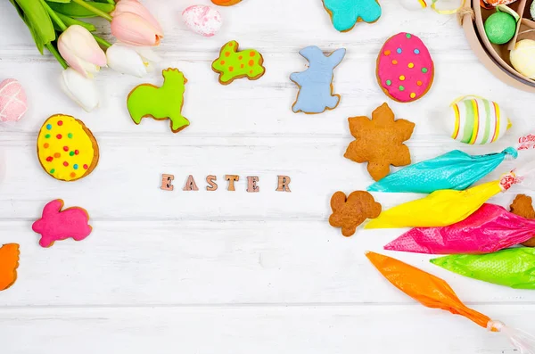 Mädchen dekorieren Lebkuchen mit Zuckerguss für Ostern — Stockfoto