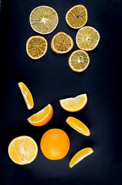 Getrocknete und roh geschnittene Orangen auf dunklem Hintergrund — Stockfoto