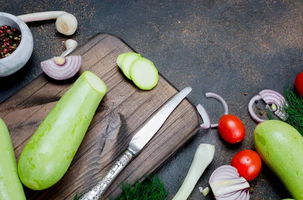 Junge Frühlingszucchini, Tomaten, Kräuter und Gewürze auf schwarzem Backblech — Stockfoto